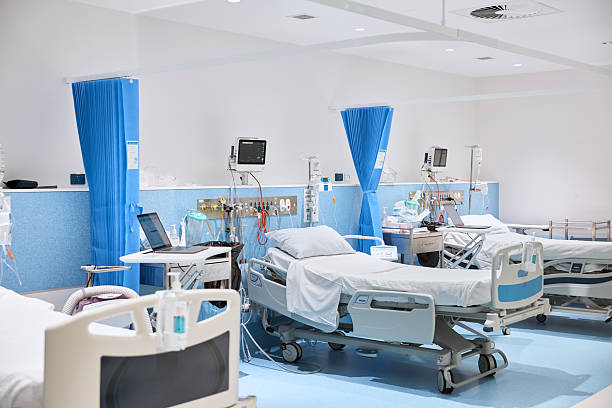 Empty gurneys in a hospital ward with medical equipment, IV drips, and monitors arranged for patient care, representing a modern and well-equipped healthcare facility, highlighting the focus keyword best fertility clinic.