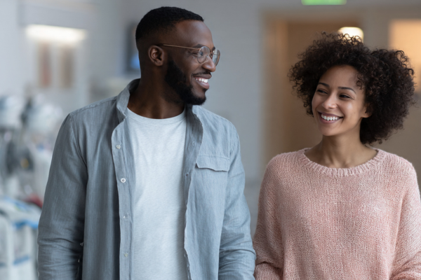 IVF & Assisted Reproduction: a happy couple holding hands in a fertility clinic, symbolizing hope and successful treatment